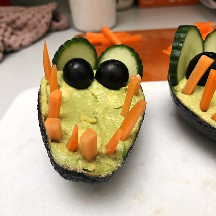 Cute crocodile guacamole in avocado with carrot teeth